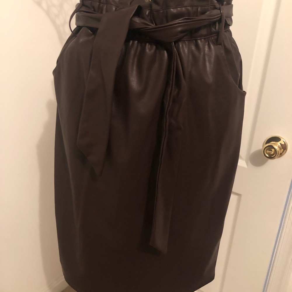 Dark chocolate faux leather pencil skirt with pocket and belt.